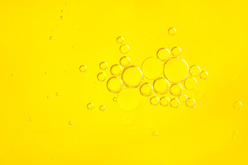 Beautiful cosmetic background. yellow abstract oil bubbles or face serum background.