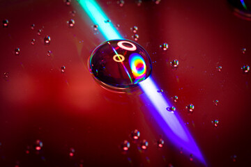 Light reflecting over water drop on CD