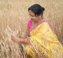 Beautiful young Indian woman wear in saree at the wheat field