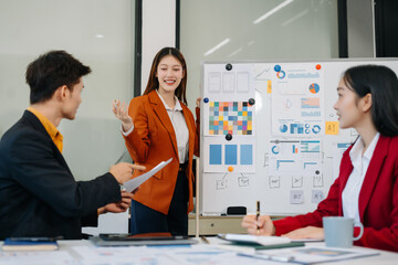 Group of professionals participating in meeting or workshop. presenter standing near flip chart give presentation interact with participants, attendee ask questions, share opinion or solutions.