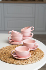 Pink ceramic cup and saucer on light dining table in dining room