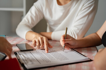 Couple reviewing and signing a real estate contract together at a table