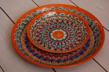 Two beautiful ceramic dishes with oriental patterns lie on a table made of white boards.