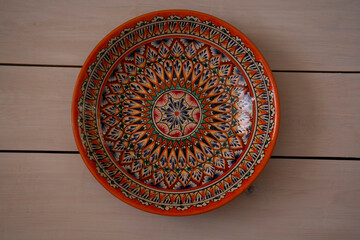 Beautiful ceramic dish with oriental patterns on a background of white boards