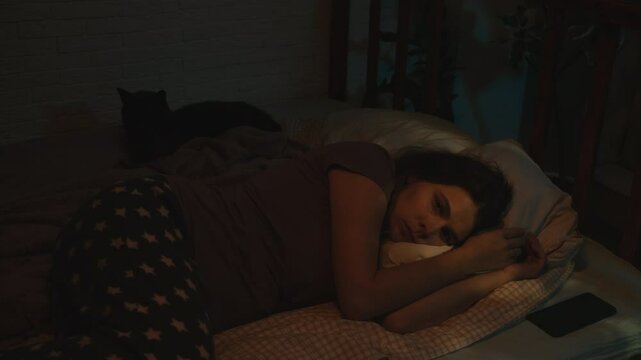 Sleeplessness. Insomniac woman can't fall asleep at night, lying awake in bed. 