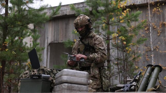 Mobile military base, soldier engineer transmits aerial pictures and data from drone to artillery. Concept of smart war by robots	
