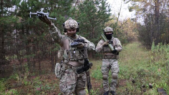 Soldier launches an unmanned army drone to monitor enemy positions and target artillery. Concept modern art of war with technology robots.