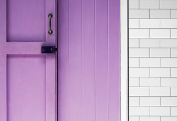 Old wooden barn door with metal door handles, Architectural background with purple wooden door and grey tile texture background
