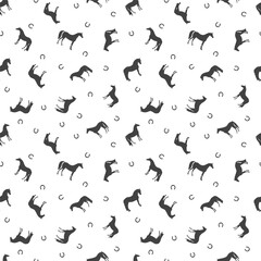 Seamless vector pattern, silhouettes of horses and horseshoes, chaotic arrangement