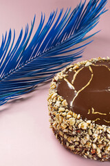 closeup of a birthday cake with cream and chocolate and a blue feather