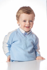 Emotional baby in shirt and blue jumper on white background