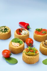 Mini Savoury Tarts with Fresh Ingredients on Light Blue Background