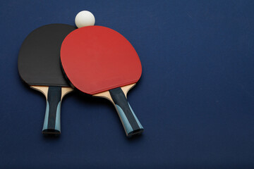 Professional Table Tennis Equipment Set with Black and Red Paddles on Dark Blue Background
