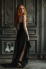 Fototapeta premium Woman in a black dress with sheer overlay, red hair and high heels. High fashion, elegant and stylish modeling.