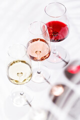 Three wine glasses filled with red, white, and rose wine