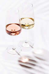 Two wine glasses filled with rose and white wine