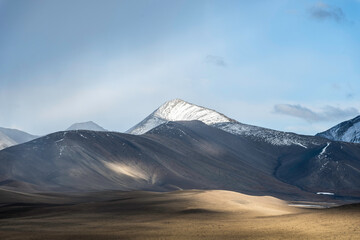 Lichteffekte auf felsiger Berglandschaft mit schneebedecktem Berg im Hintergrund