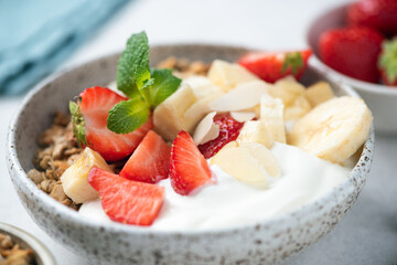 Coconut yogurt bowl with fresh fruits and granola, closeup view