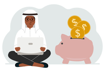 A man sits cross-legged with a laptop next to a pig piggy bank. Earning money, saving, saving money.