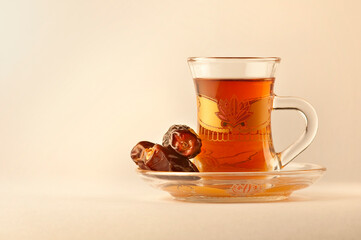 A close up of a cup of Arabic tea and dates. Sulemani tea -a favorite Middle eastern hot drink.