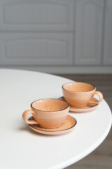 Ceramic mug with saucer on kitchen light table