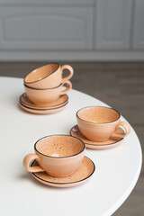 Ceramic mug with saucer on kitchen light table