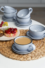 Ceramic mug with saucer on kitchen light table