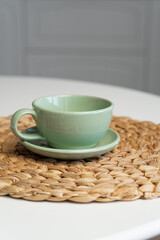 Ceramic mug with saucer on kitchen light table