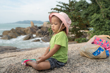 Adorable little asian toddler girl ejoy play colorful toy on sea white sand beach