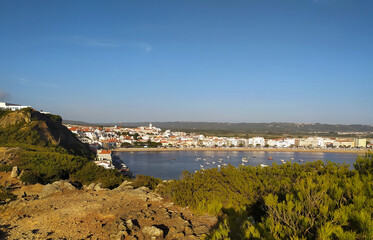 Coastal view of a vibrant waterfront town with boats in the harbor on a clear sunny day