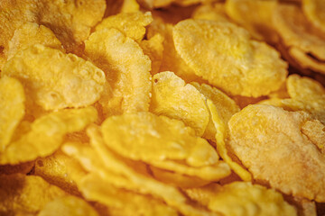 A detailed macro shot of golden cornflakes with a crispy texture and bright yellow color, highlighting their natural appeal.