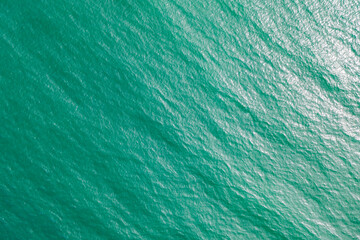 Ocean texture, drone view of the turquoise ocean water surface.