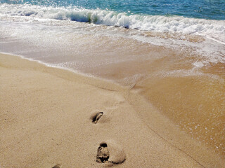 A serene beach at midday with gentle waves lapping the shore and clear blue skies inviting...
