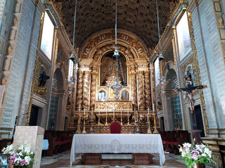 Ornate interior of a historic church featuring intricate details and decorative altar