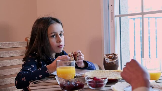 Girl Enjoying Crepes with Toppings and Orange Juice on Shrove Tuesday