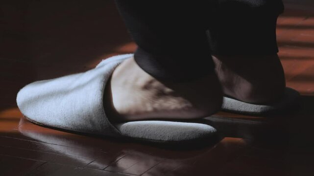 Foot wear a pair of casual wool slippers for in the house. Natural light and shadow on home slippers. Comfortable and cozy living.