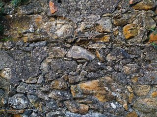 Rustic stone wall texture.  Irregularly shaped stones in shades of gray and brown, set in mortar. Perfect for backgrounds, textures, or design projects needing a vintage, aged aesthetic.