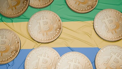 Several bitcoins are laid out on the flag of Gabon