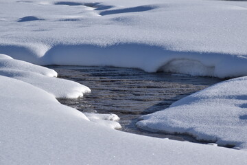 icy river flowing thru the snowy meadow