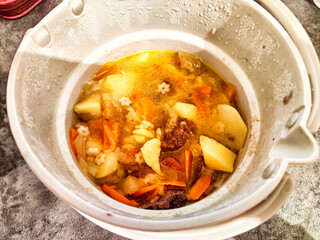 Hearty vegetable and meat stew simmering in a pot filled with fresh ingredients and rich broth