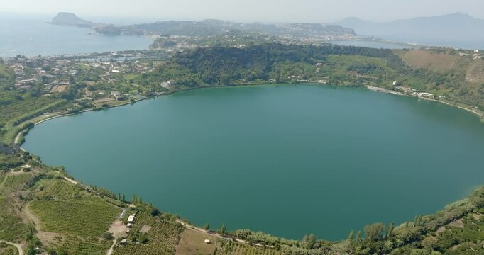 Aerial view of Lake Avernus (Lago d'Averno) located Pozzuoli, near Naples, in Campania, Italy. It is a volcanic crater lake located in Phlegraean Fields (Campi Flegrei). The lake is roughly circular.