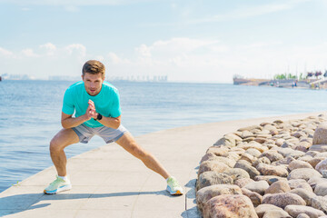 Fitness enthusiast performs lateral lunges by the waterfront on a sunny day