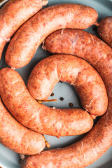 Homemade sausage cooked in sous vide on a blue plate on a wooden background. Close-up.