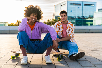 Young multiethnic modern couple with skateboards dating outdoors - Two friends having fun skating...