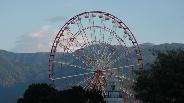 The Ferris wheel against the mountains in summer