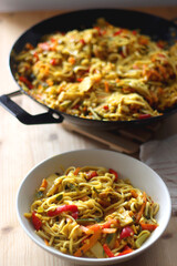 Bowl of stir fry vegetables and noodles, served on the table. Selective focus.