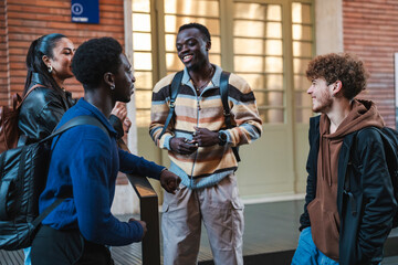 Four young adults engage in a friendly conversation while standing outside a modern building, wearing casual outfits and backpacks, emphasizing teamwork and connection in a relaxed urban setting.