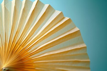 Yellow paper fan against a teal background.