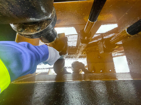 Heavy fuel oil tank overflow pipe deep tray with fuel residues inside on board of merchant cargo ship