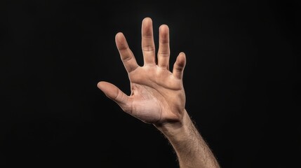 Fototapeta premium man hand raised against black background, showcasing gesture of openness and communication. image captures intricate details of hand structure and skin tone
